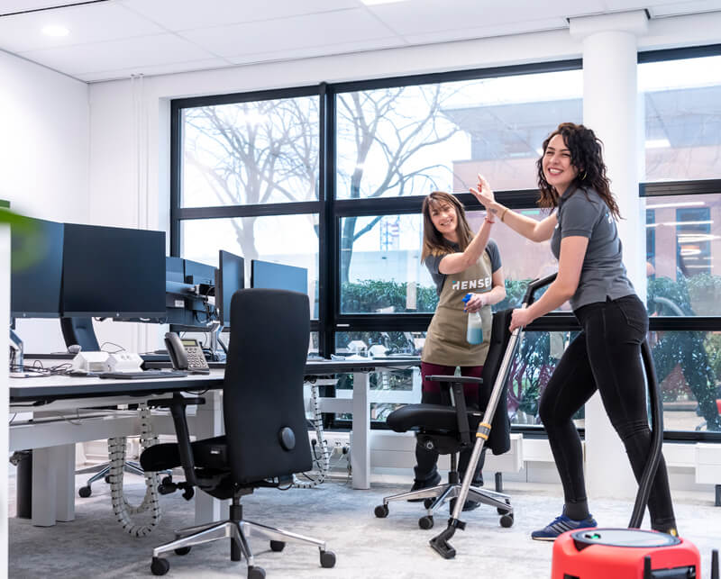 Professionele schoonmaaksters van schoonmaakbedrijf Hensen Cleaning aan het werk in een kantoor